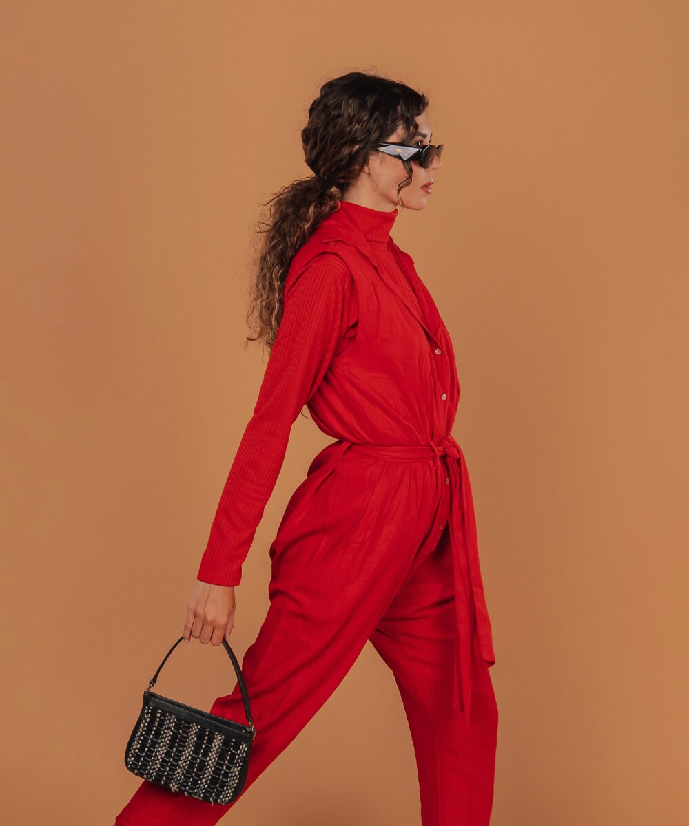 Woman in a red outfit carrying a small black woven handbag