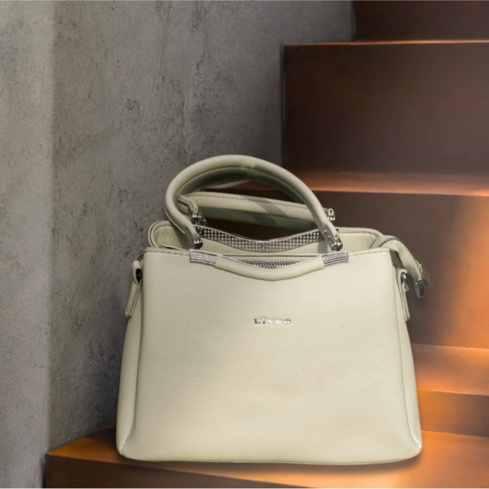 Cream Lisbo structured handbag with dual top handles on stone steps