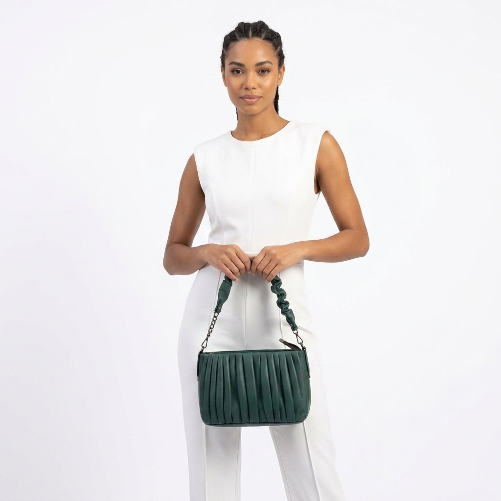 Model in white holding the deep teal pleated shoulder bag